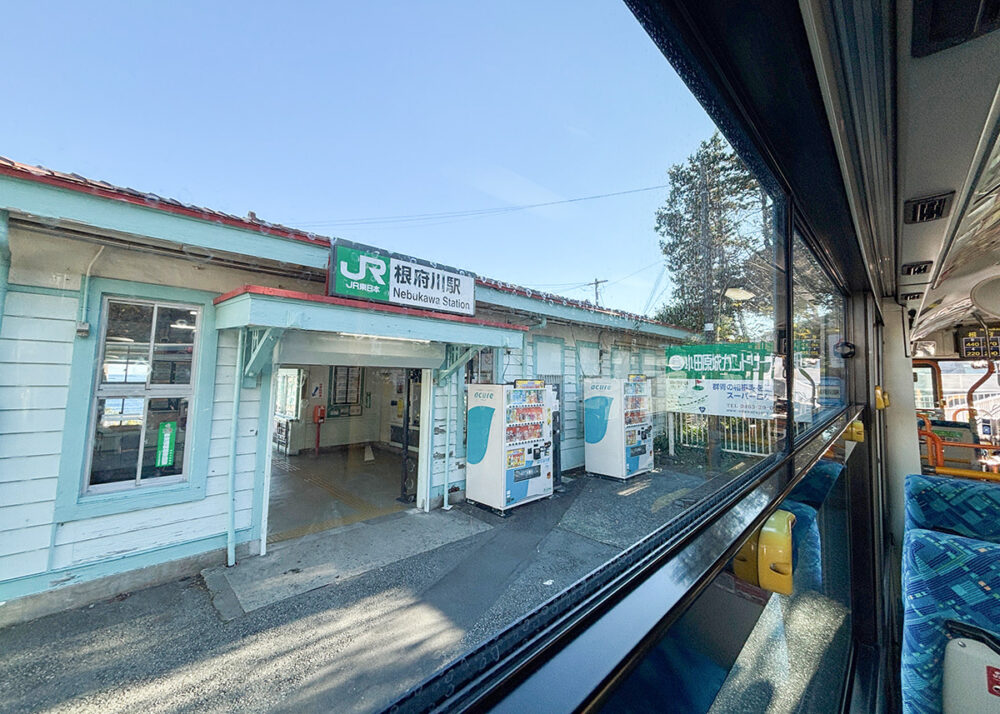 1924年築の木造駅舎が今も使われている根府川駅前を経由